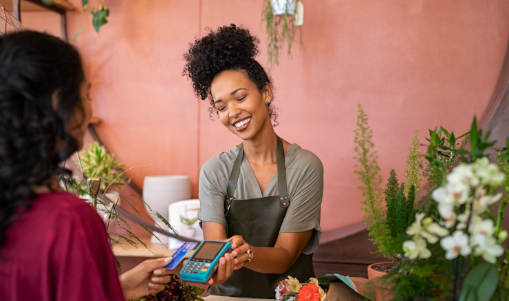 Successful business owner processing payments with modern POS system